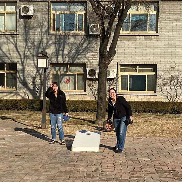staff enjoying cornhole outdoors while restricted to campus