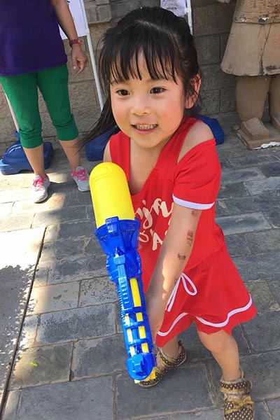 the water gun is almost bigger than her grin