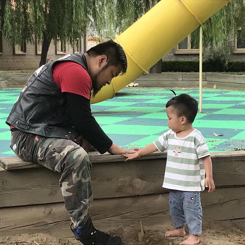 motorcycle club member gently makes friends with preschool orphan