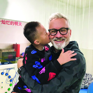 Tim holding young boy in China