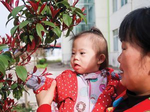 child at healing home investigating a flower