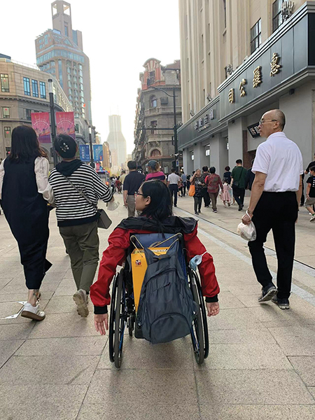 Wendy in her wheelchair travels a city street independently