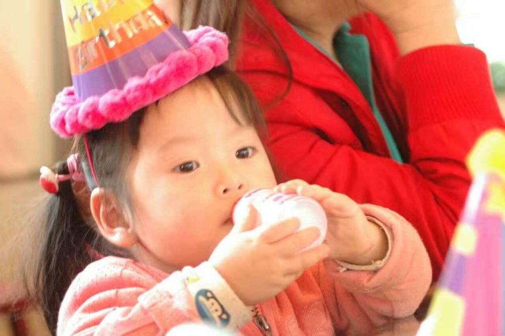 chinese baby with bottle demonstrates need for formula