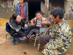 chinese boy in wheelchair with adults on each side