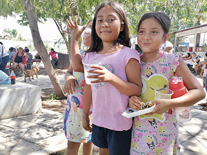 two local Mexican girls enjoying a healthy snack provided by PHF