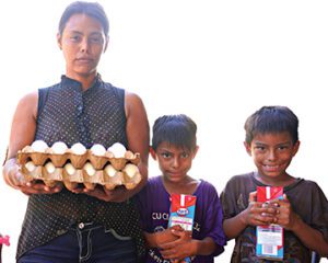 Mama and two boys proudly display gifts of milk and eggs